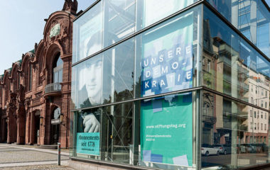 Fassade mit Schrifzug auf Poster: Unsere Demokratie